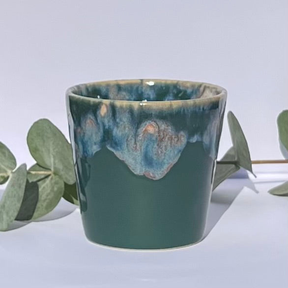 Aromatherapy candle in a deep hunter green stoneware coffee cup, crafted with natural wax and essential oils. Handmade by Kilimanjaro Candles & More for a luxurious, eco-friendly touch.